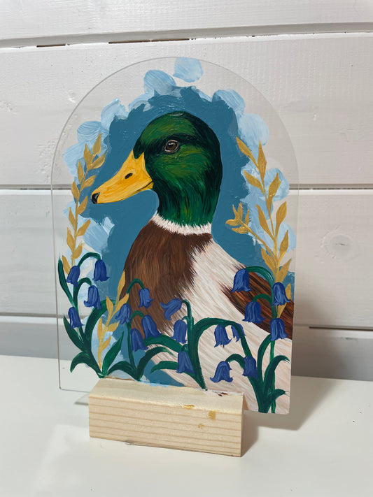 Decorative sign with a painted duck and floral design on a white background